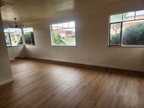 Denver apartment for rent - A room with wooden floors and two windows.