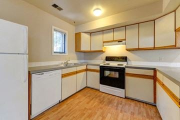 Boulder triplex for rent - a kitchen with white cabinets and a stove and a refrigerator
