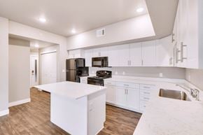 Fort Collins apartment for rent - A modern kitchen with white cabinets and a wooden floor.