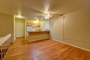 Boulder condo for rent - an empty living room and kitchen with a wood floor