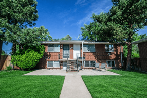 Denver apartment for rent - A red brick apartment building with a green lawn in front.