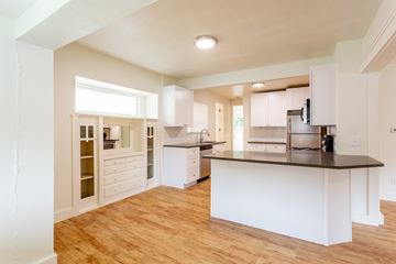 Boulder apartment for rent - A kitchen with white cabinets and a wooden floor.