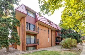 Boulder apartment for rent - A red brick building with a red roof and balconies.