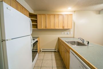 Boulder apartment for rent - A kitchen with a white refrigerator and wooden cabinets.