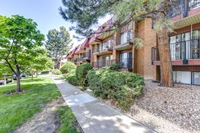 Boulder condo for rent - a sidewalk in front of a brick apartment building with trees