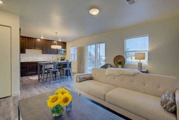 Greeley apartment for rent - a living room and kitchen with a couch and a table