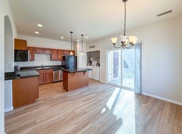 Thornton apartment for rent - A kitchen with wooden cabinets and a black countertop.