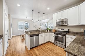 Denver townhouse for rent - A kitchen with white cabinets and granite countertops.