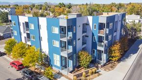 Lakewood apartment for rent - A blue and white apartment building with a red car parked in front.