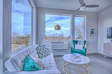 Denver apartment for rent - A living room with a white couch and a gold coffee table.