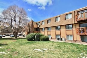 Aurora apartment for rent - Apartment building with a green bush in front.