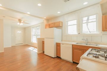 Boulder apartment for rent - A kitchen with a white refrigerator, wooden cabinets, and a stove top oven.