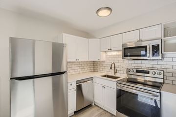 Louisville apartment for rent - A kitchen with white cabinets and a stainless steel refrigerator.