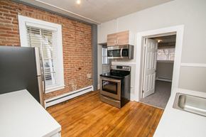 Boulder apartment for rent - an empty kitchen with a brick wall and a window