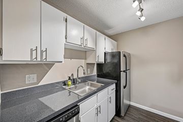 Lakewood apartment for rent - A kitchen with a black refrigerator and white cabinets.