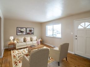 Denver apartment for rent - A living room with a couch, chairs, and pictures on the wall.