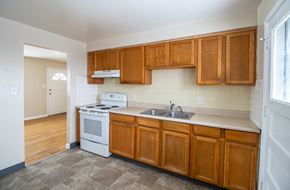 Denver apartment for rent - A kitchen with wooden cabinets and a white stove top oven.