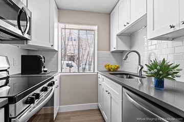 Denver apartment for rent - A modern kitchen with white cabinets and stainless steel appliances.