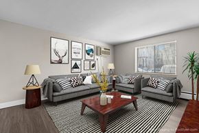 Denver apartment for rent - A living room with a grey couch, a coffee table, and a plant.