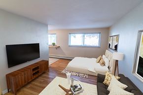 Denver apartment for rent - A living room with a white couch and a wooden entertainment center.