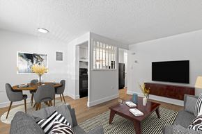 Denver apartment for rent - A living room with a grey couch, a coffee table, and a television.