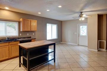 Denver apartment for rent - A kitchen with a black counter top and wooden cabinets.
