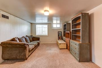 Denver apartment for rent - A living room with a brown couch and a window.