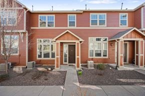 Castle Rock apartment for rent - A red two-story house with a front yard and a driveway.