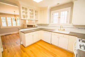 Denver apartment for rent - A kitchen with white cabinets and a wooden floor.