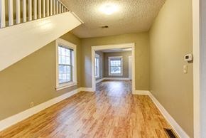 Boulder apartment for rent - A room with wooden floors and a staircase leading to the upper floor.