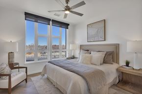 Denver apartment for rent - a bedroom with a large bed and a ceiling fan