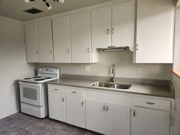 Denver apartment for rent - A kitchen with white cabinets and a stove top oven.