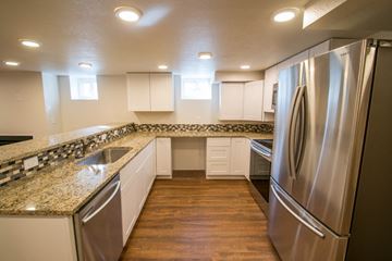 Denver apartment for rent - A modern kitchen with a stainless steel refrigerator and granite countertops.