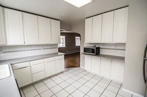 Edgewater apartment for rent - A kitchen with white cabinets and a tiled floor.
