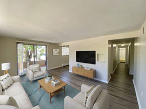 Denver apartment for rent - A living room with a white couch, a wooden coffee table, and a flat screen TV.