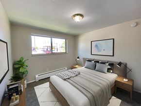 Denver apartment for rent - A bedroom with a large bed and a window overlooking a street.
