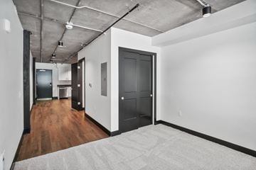 Greeley apartment for rent - a living room with a gray rug and white walls and a black door