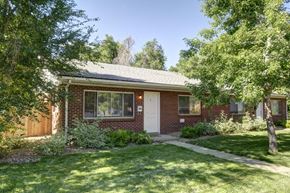 Boulder triplex for rent - A red brick house with a white door and windows.