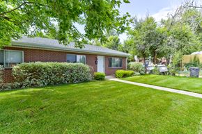 Boulder triplex for rent - A house with a green lawn and a white pathway leading to the front door.