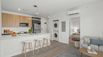 Denver apartment for rent - A modern kitchen with white cabinets and a wooden island.