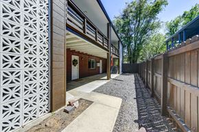 Boulder apartment for rent - A modern house with a white and brown exterior and a gravel pathway leading to the entrance.