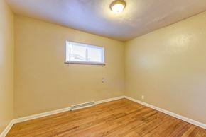Denver apartment for rent - the bedroom of a home with wood flooring and a window