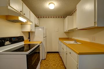 Boulder apartment for rent - an empty kitchen with white appliances and yellow counter tops