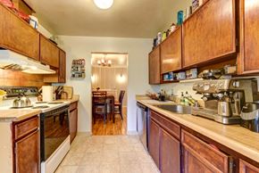 Boulder apartment for rent - a kitchen with wooden cabinets and appliances and a dining room in the background