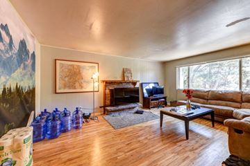 Boulder apartment for rent - A living room with a fireplace and a painting of a mountain scene on the wall.