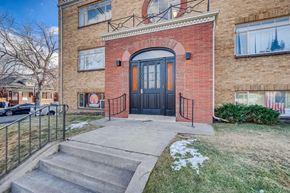 Denver apartment for rent - A red brick house with a black door and a small porch.