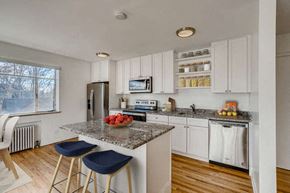 Denver apartment for rent - A kitchen with white cabinets and a granite countertop.