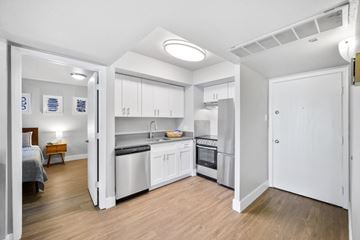 Fort Collins townhouse for rent - a renovated kitchen with white cabinets and stainless steel appliances