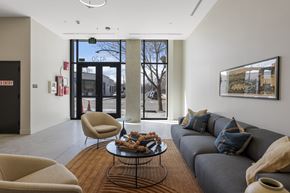 Denver apartment for rent - A modern living room with a grey couch, a coffee table, and a large window.