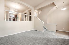 Castle Rock apartment for rent - A spacious room with a carpeted floor and a staircase leading to another level.